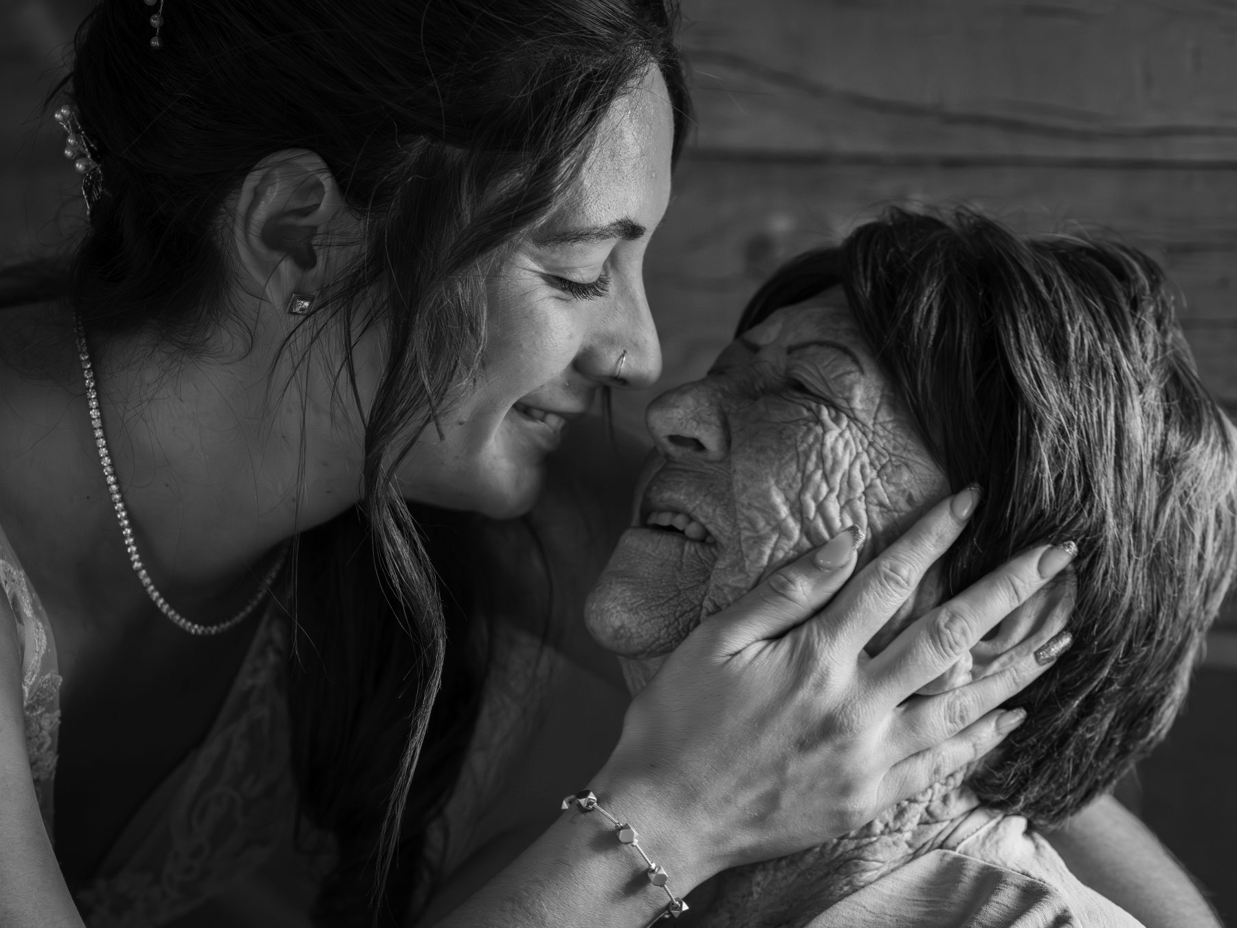 Novia besando tiernamente la mejilla de su abuela, gesto de amor, blanco y negro – fotografía de bodas por VicmanArt