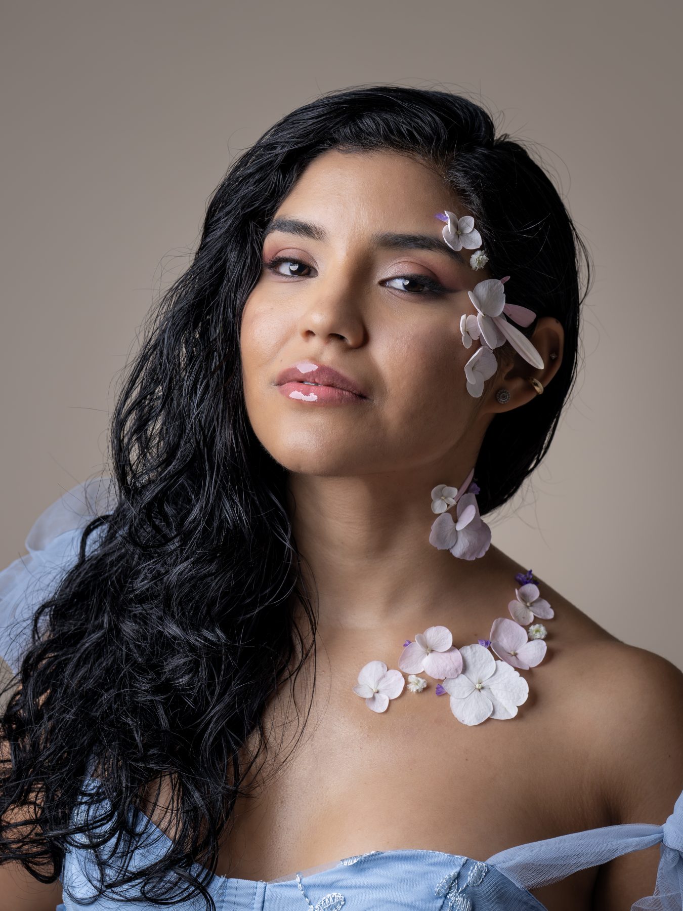 Model with hydrangea flowers in her hair and an embroidered blue dress, studio portrait – portrait photography by VicmanArt
