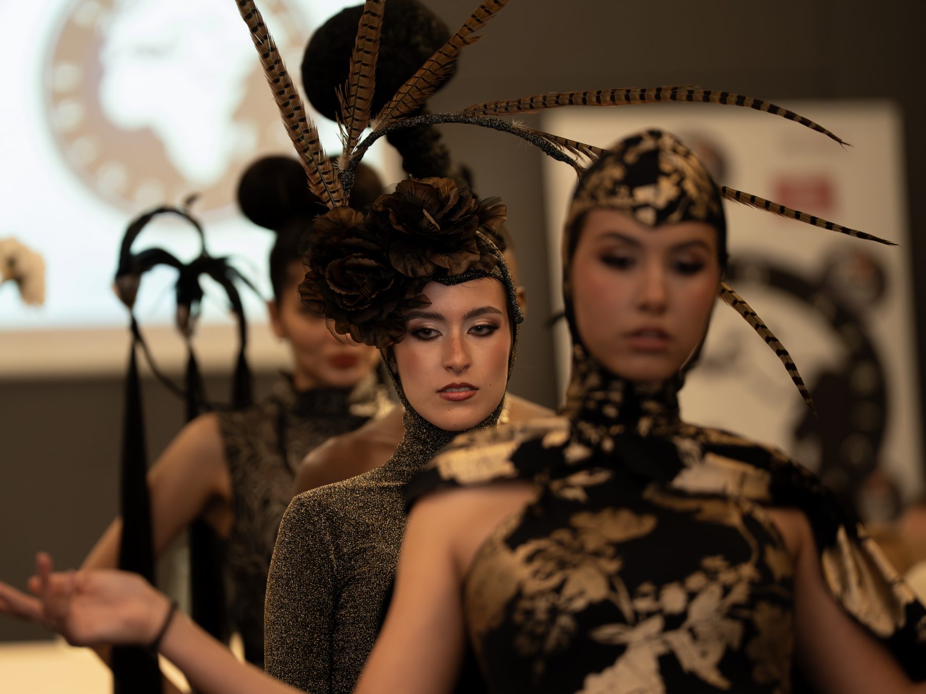 Model with an elaborate headpiece of flowers and black spheres, portrait backstage at a fashion show in Barcelona – fashion show photography by VicmanArt