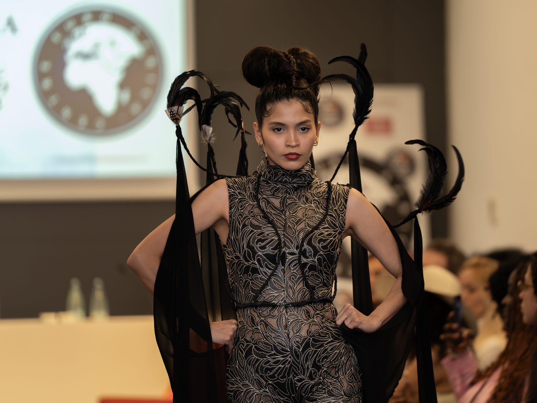 Runway model in an embroidered dress and artistic black headpiece with ribbons in Barcelona – fashion show photography by VicmanArt