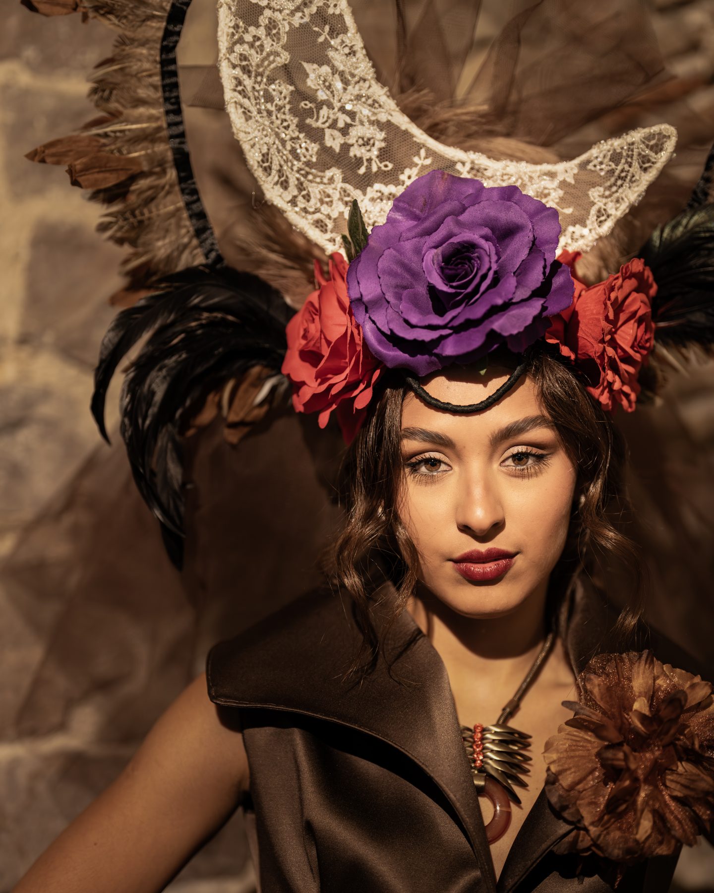 Model with an artistic headpiece of purple flowers and dark feathers, backstage portrait in Barcelona – backstage fashion photography by VicmanArt